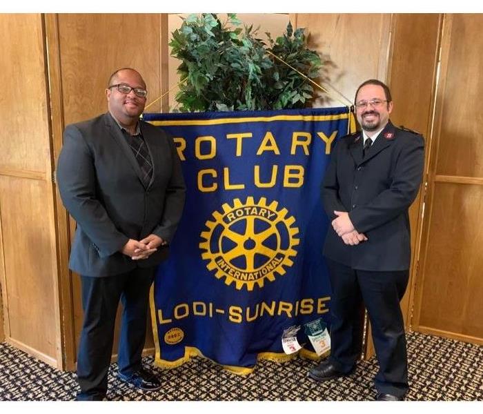 Paul Anderson Gives Speech to the Sunrise Rotary Club - image of two men standing in suits