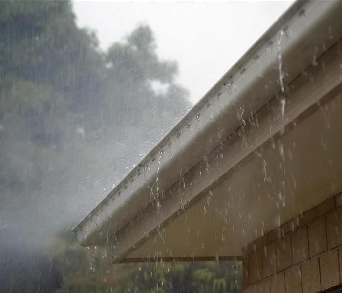 gutter on a house with rain pouring down