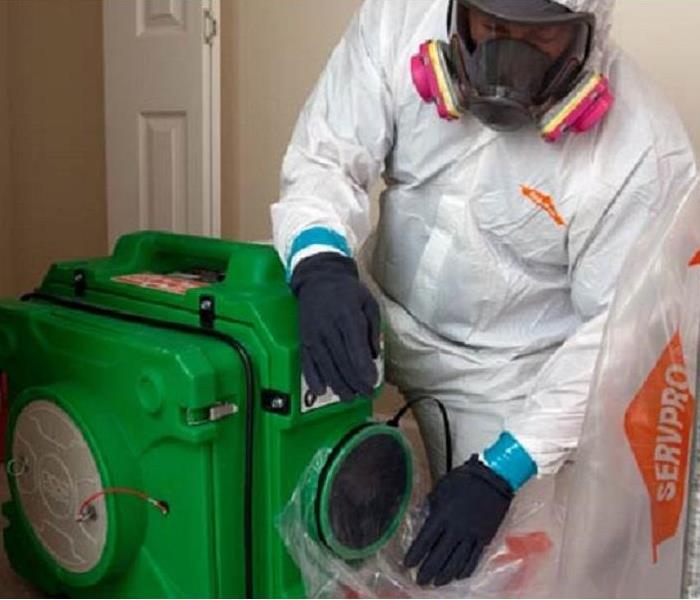SERVPRO employee cleaning sewage with professional equipment