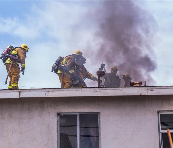 Roof on fire with firemen putting out the fire