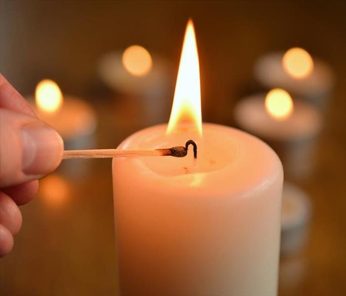 man lighting a candle with a match