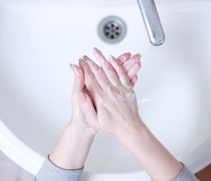 woman washing hands in a bathroom sink